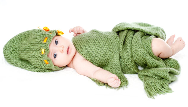 adorable baby in green knitted hat and blanket