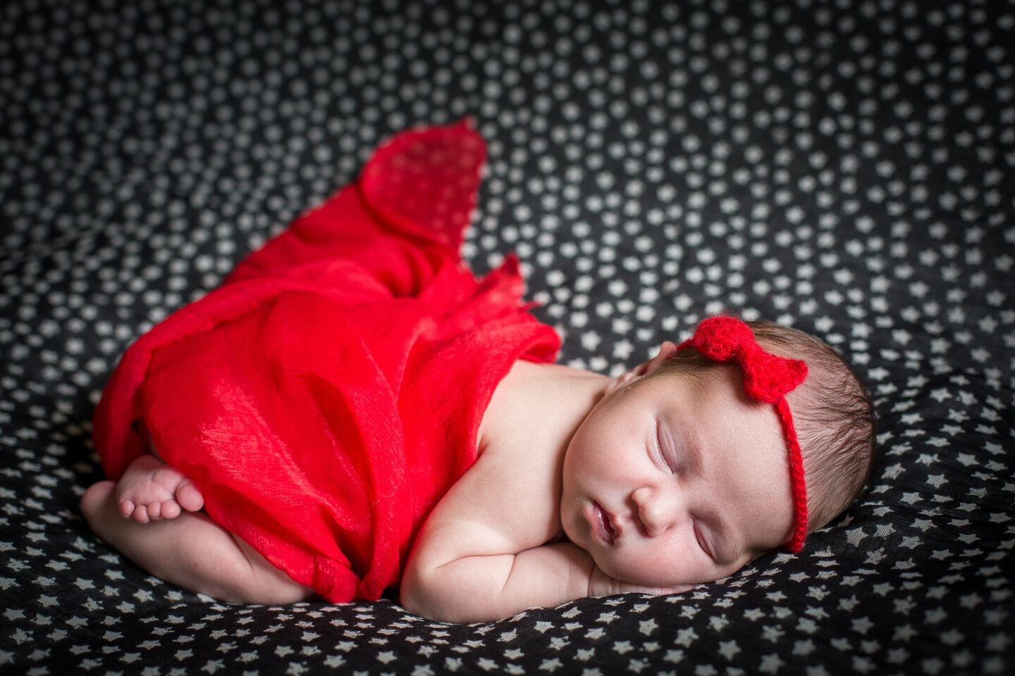 Sleeping newborn in red dress